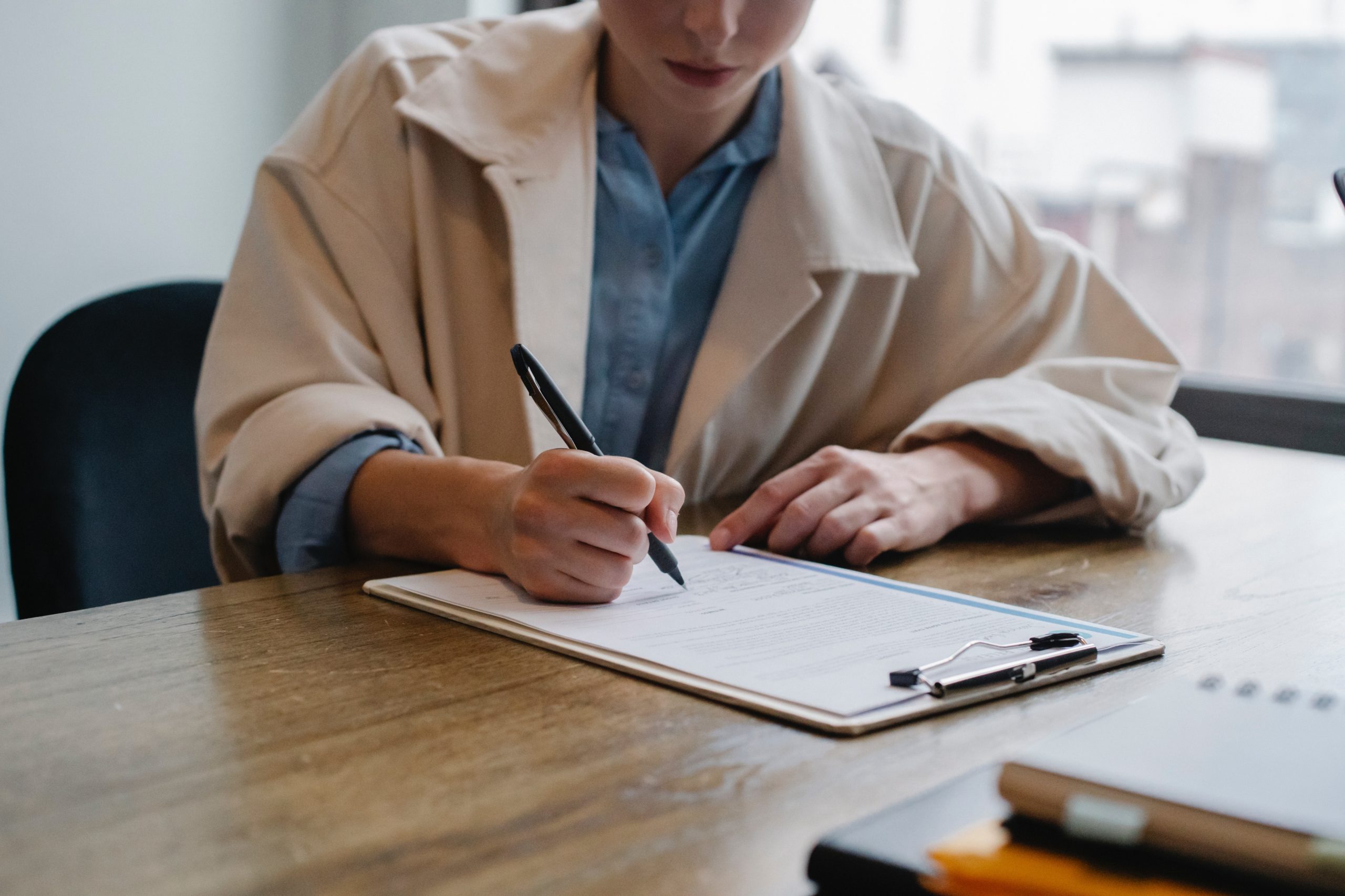 Woman in an office writing on a clipboard