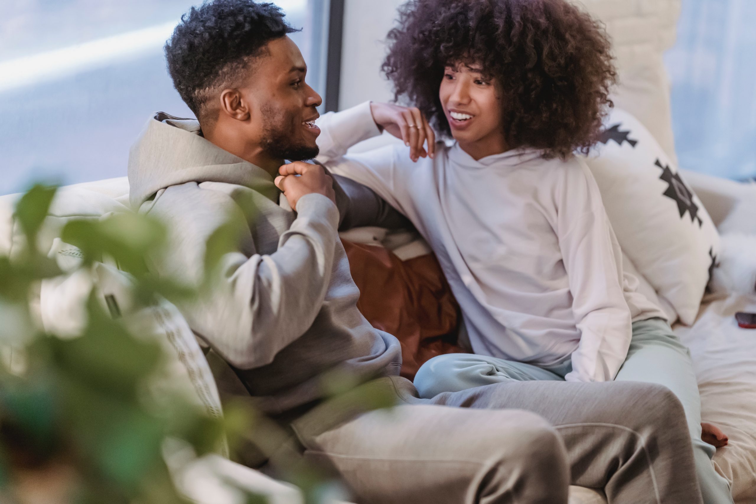 Couple smiling and talking while sitting on a couch