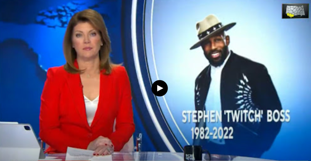 caucasian woman wearing red blazer and white blouse side by black man smiling with off white hat with brim, dark colored sports jacket
