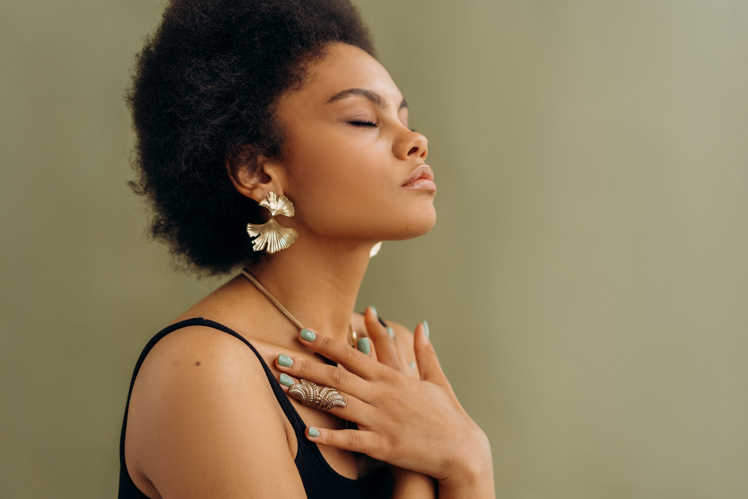 woman sitting with eyes closed and hands across her chest practicing breathwork