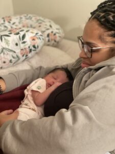 Brenda Leger, student parent holding her baby in her arms