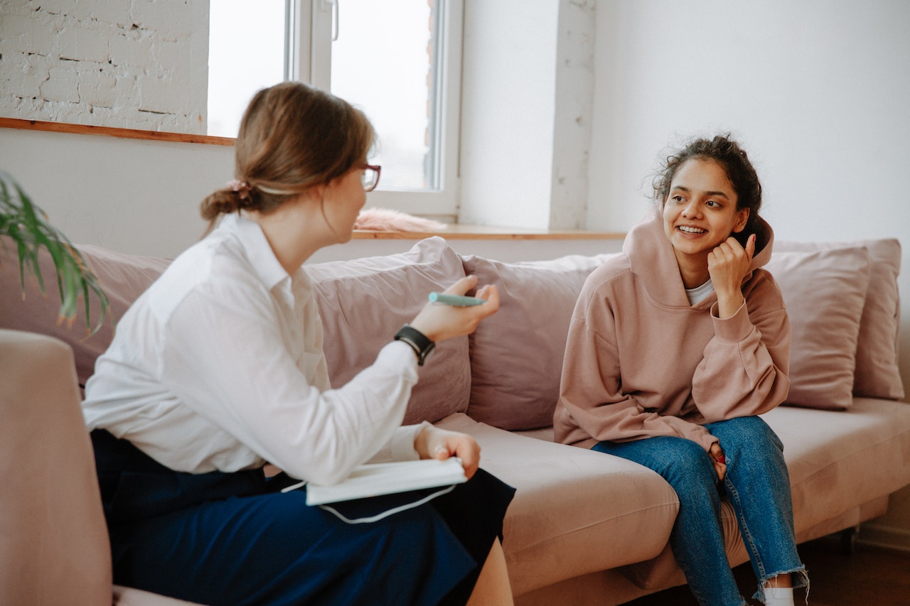 young person sitting on the couch speaking to a therapist