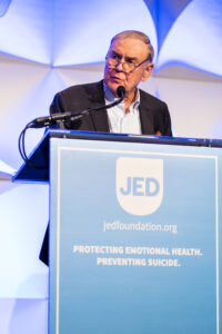 Phil Satow speaking at podium during end of gala