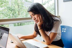 student starting at computer thinking