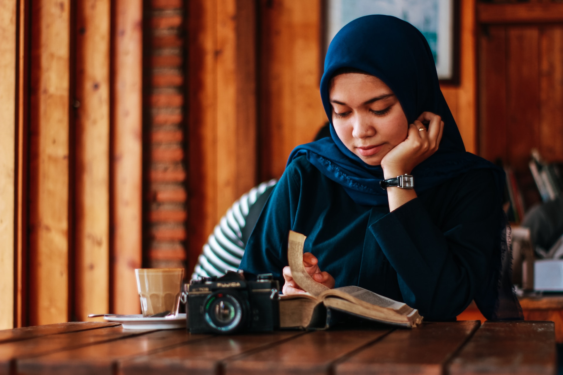 international student sitting at table reading a book