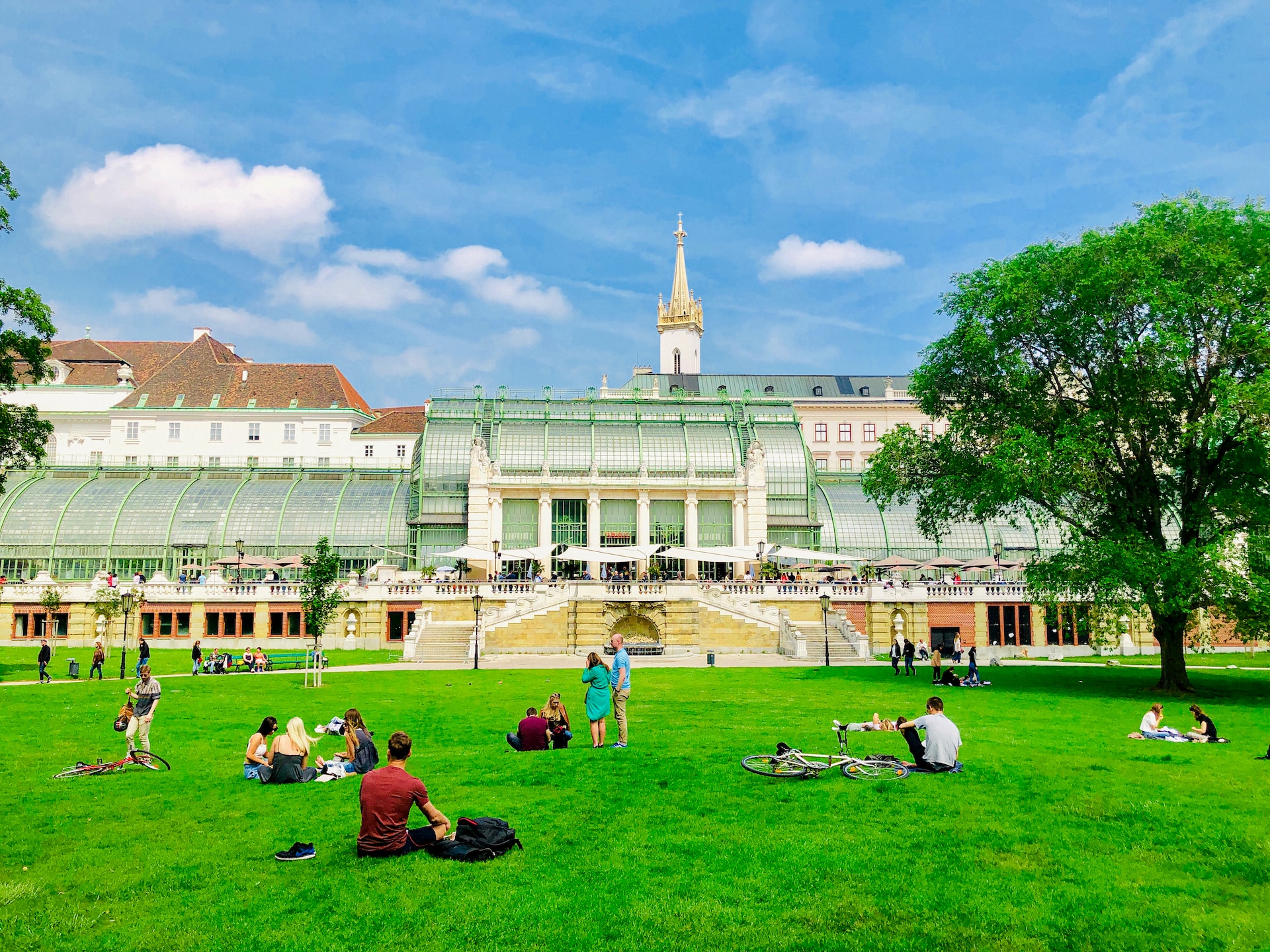 college visit with students sitting on lawn and campus buildings in the background