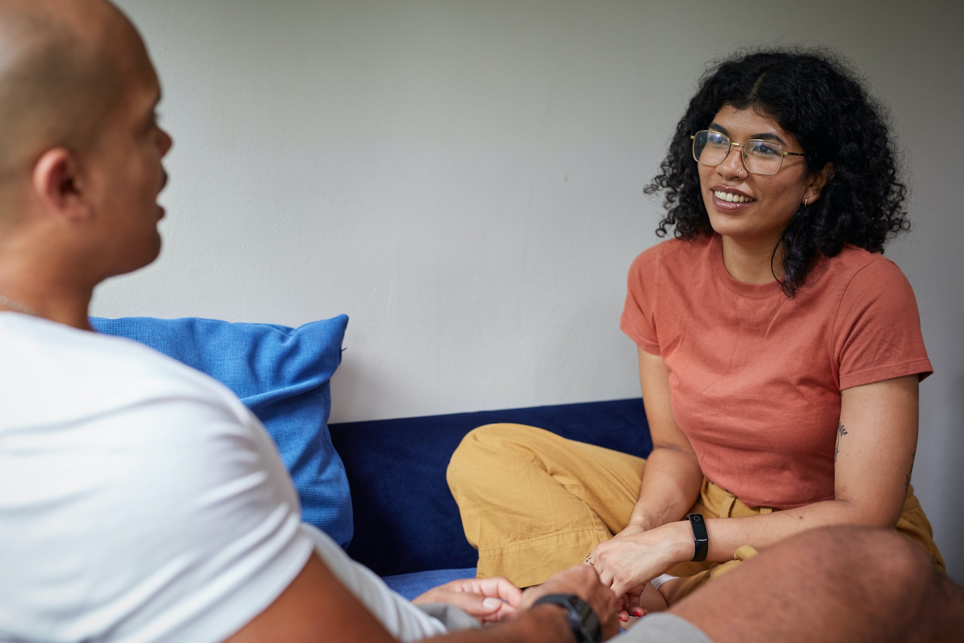 two college students sitting on couch facing each other and talking