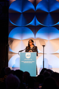 woman standing at podium speaking into the microphone