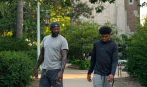 man and young male walking together in a park