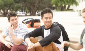 young people sitting on the beach talking