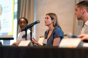 panel of speakers, speaking into microphones to the audience